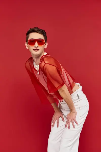 Good looking modish androgynous man with red stylish fishnet and sunglasses looking at camera — Stock Photo