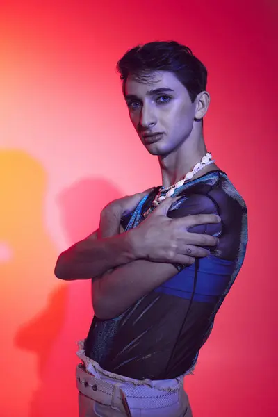 Alluring androgynous fashionista with accessories in casual attire posing and looking at camera — Stock Photo