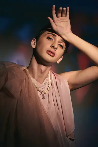 Fantaisie fashionista androgyne aux cheveux foncés en tenue pastel en regardant la caméra sur fond vif — Photo de stock