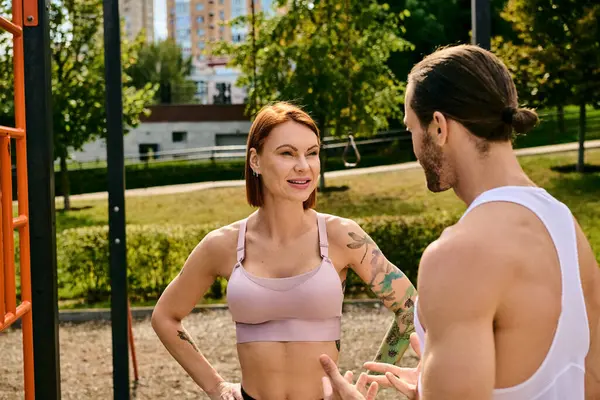 A determined woman in sportswear exercising together with a personal trainer at a playground. — Stock Photo