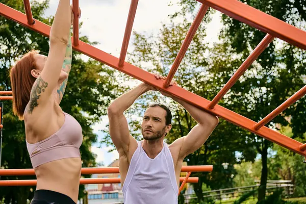Una donna in abbigliamento sportivo esercitare insieme all'aperto con personal trainer, mostrando determinazione e motivazione. — Foto stock