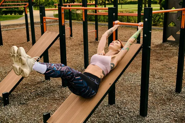 Una donna in abbigliamento sportivo che lavora su una panchina, immersa nel verde in un parco. — Foto stock
