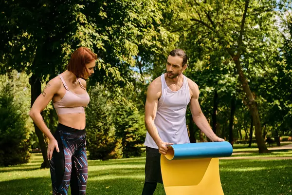 Une femme en tenue de sport, avec un entraîneur personnel faisant de l'exercice dans un parc, faisant preuve de détermination et de motivation. — Photo de stock