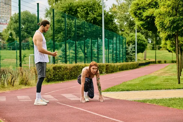 A man and a woman in sportswear stand confidently on a court, showcasing determination and motivation with their personal trainer. — Stock Photo
