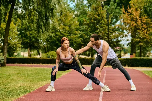 A woman in sportswear being guided by a personal trainer, exuding determination and motivation. — Stock Photo