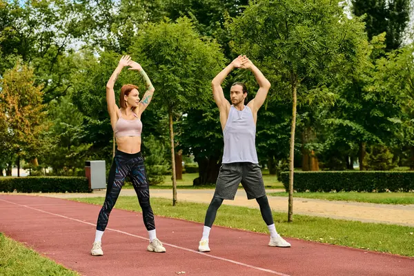 Um personal trainer guia uma mulher em sportswear em um ambiente vibrante parque, mostrando determinação e motivação. — Fotografia de Stock