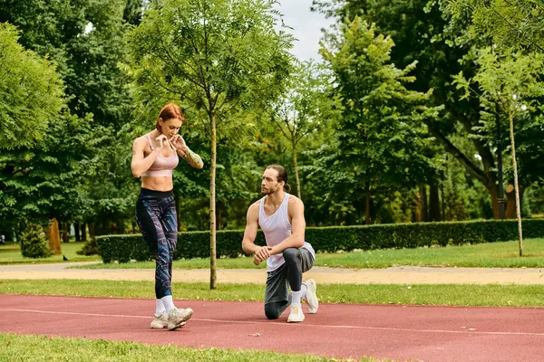 Um personal trainer guia uma mulher em sportswear através de exercícios ao ar livre em um banco de parque, mostrando determinação e motivação. — Fotografia de Stock