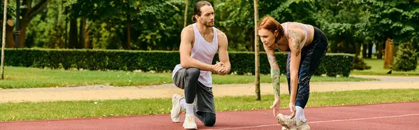 Une femme déterminée en vêtements de sport pratique le sport avec un entraîneur personnel par une journée ensoleillée en plein air. — Photo de stock