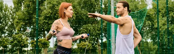Una mujer en ropa deportiva se destaca al aire libre, motivada por un entrenador personal. - foto de stock