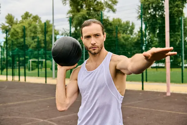 A man holds a ball in one hand and a ball in the other, showing determination and focus in his exercise routine. — Stock Photo