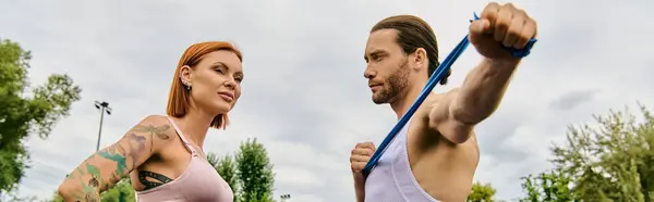Uma mulher determinada, em sportswear, liderada por um personal trainer em exercícios ao ar livre, mostrando motivação e trabalho em equipe. — Fotografia de Stock