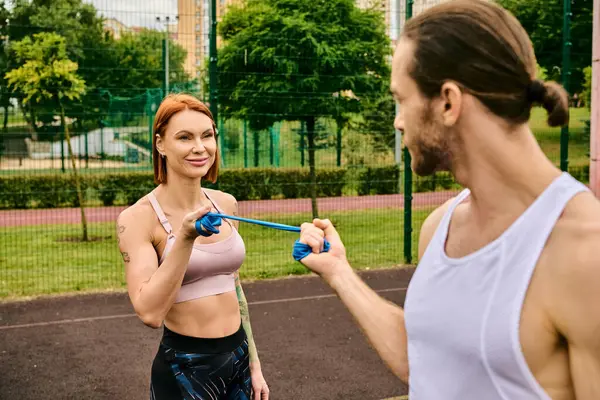 Eine Frau und ein Mann, beide in Sportbekleidung, trainieren gemeinsam im Freien — Stockfoto