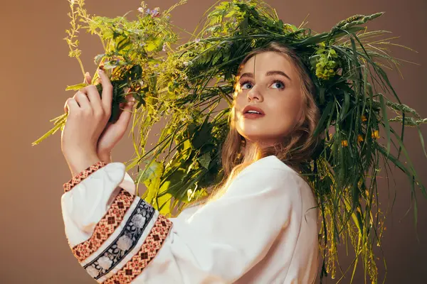 Jovem mulher vestindo uma roupa tradicional adornada com uma coroa de flores inspirada em fadas e fantasia em um estúdio. — Fotografia de Stock