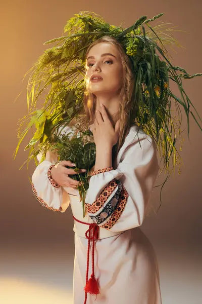 Una mujer joven con un vestido blanco delicadamente sostiene una planta vibrante en un ambiente de estudio de hadas y fantasía. - foto de stock