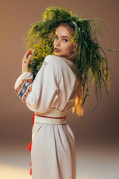 Une jeune mavka, ornée d'un vêtement traditionnel, équilibre gracieusement une plante sur sa tête dans un décor de studio féerique. — Photo de stock