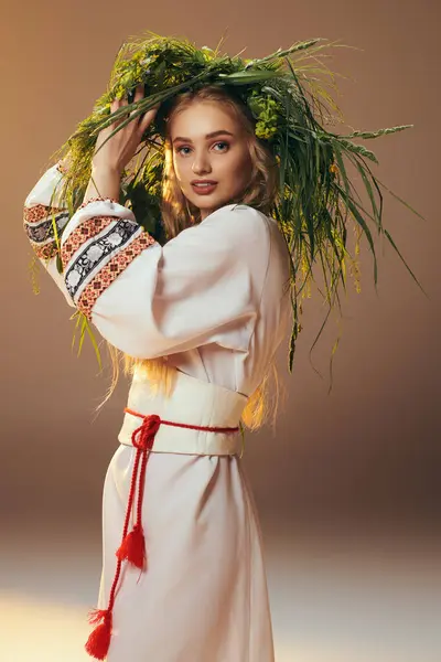Молодая женщина в белом платье, украшенном нежным венком на голове, источает мистический шарм в студии. — стоковое фото