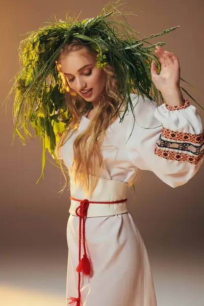 Eine junge Frau in einem weißen Kleid, mit einem komplizierten Kranz auf dem Kopf, verströmt eine ätherische und märchenhafte Präsenz in einem Atelierhaus. — Stockfoto