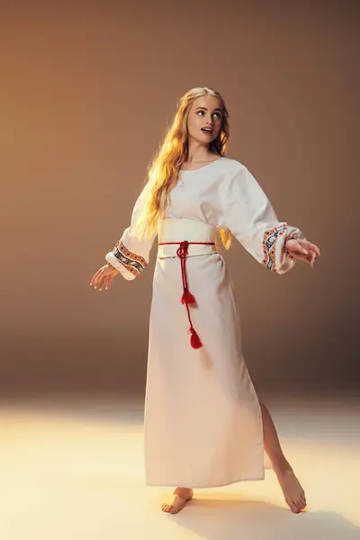 Eine junge Mavka-ähnliche Gestalt schmückt ein weißes Kleid mit einem komplizierten roten Gürtel und verströmt einen Hauch von Verzauberung in einem skurrilen Studio-Setting. — Stockfoto