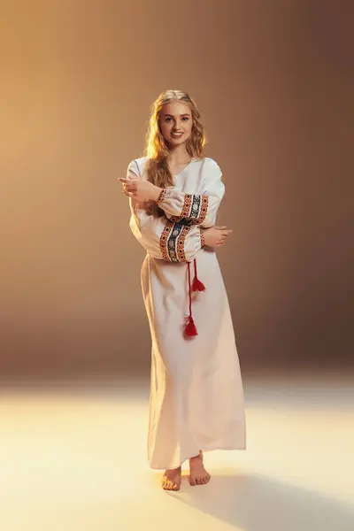 Молода жінка в традиційній білій сукні вражає позу в фентезі-студії. — стокове фото