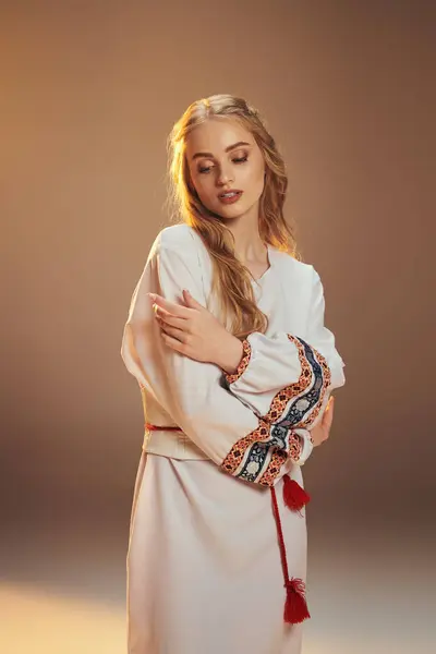 Eine junge Mavka steht anmutig in einem traditionellen weißen Kleid mit auffallend roter Quaste und verströmt einen Hauch ätherischer Schönheit. — Stockfoto