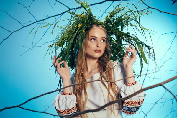 Young mavka in traditional outfit, adorned with fairy-like leaf wreath, exuding a mystical presence in a studio setting. — Stock Photo