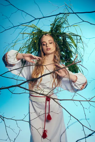 Um jovem mavka em um vestido branco segura suavemente um galho de árvore em um estúdio mágico e surreal. — Fotografia de Stock