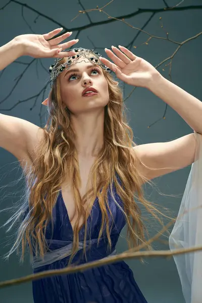Una giovane donna in un abito blu mozzafiato ornata con una corona sulla testa, trasudando un'aura di regalità fiabesca. — Foto stock