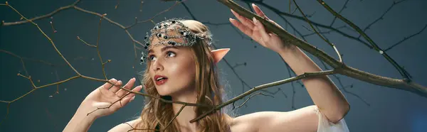 Uma jovem mulher em um vestido adornado com uma coroa de ramos em sua cabeça, incorporando a essência de uma princesa duende conto de fadas. — Fotografia de Stock