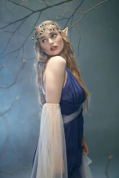 Eine junge Frau in einem atemberaubenden blauen Kleid und einem königlichen Diadem, die das Wesen einer Märchenelfenprinzessin verkörpert. — Stockfoto