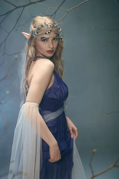 Une jeune femme vêtue d'une robe bleue et voilée, incarnant une princesse fée dans un décor de studio. — Photo de stock