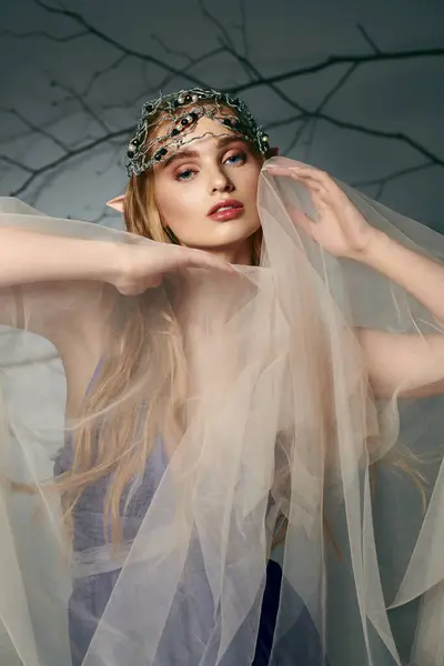 Uma jovem mulher, vestida como uma princesa elfo conto de fadas, fica com um véu graciosamente coberto sobre a cabeça. — Fotografia de Stock