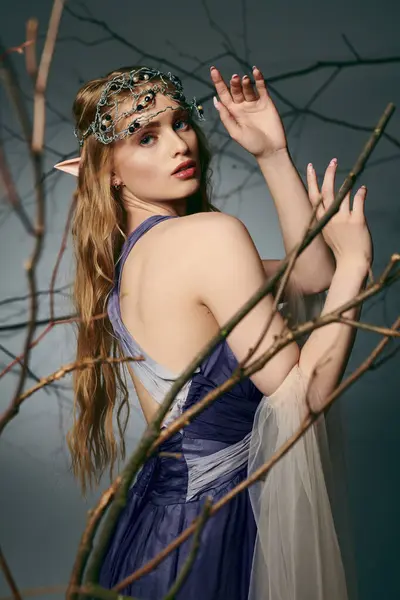 Молодая женщина в синем платье, с королевской короной на голове, воплощает сущность сказочной принцессы. — стоковое фото