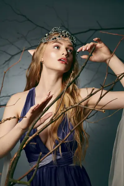 Uma jovem mulher em um vestido azul faz uma pose de princesa duende em um estúdio. — Fotografia de Stock