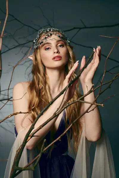 A young woman crowned in a majestic crown, dressed in a beautiful blue gown, exuding the essence of a fairy princess in a studio setting. — Stock Photo