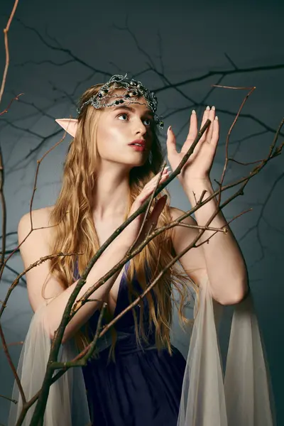 Uma jovem mulher em um vestido azul deslumbrante adornado com uma coroa, incorporando a essência de uma princesa de fadas em um ambiente de estúdio. — Fotografia de Stock