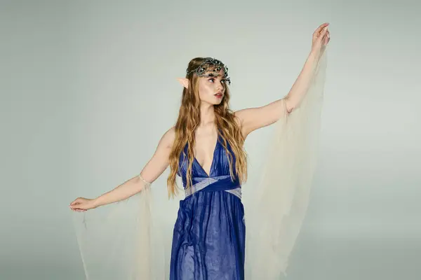 Una giovane donna vestita con un abito blu fluente e delicato velo, che incarna l'essenza di una principessa elfica mistica. — Foto stock