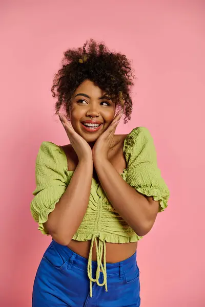 Uma bela mulher afro-americana em trajes elegantes posando com as mãos no rosto contra um cenário vibrante. — Fotografia de Stock