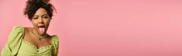Стильная афроамериканка, торчащая языком на розовом фоне.. — стоковое фото