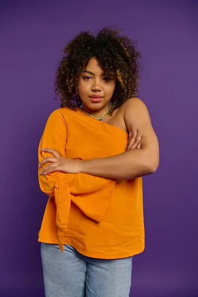 Afroamerikanerin in orangefarbenem Hemd posiert. — Stockfoto