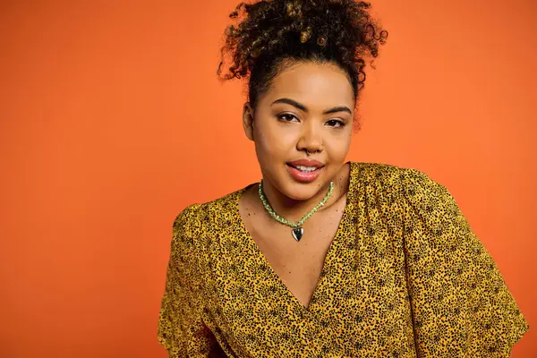 Elegant African American woman in yellow top poses for camera. — Stock Photo