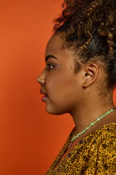 Uma bela mulher afro-americana em trajes elegantes, mostrando um colar. — Fotografia de Stock