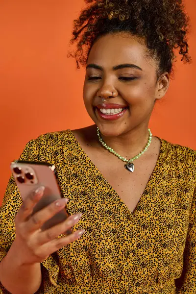 Стильная афроамериканка улыбается, пользуясь телефоном. — стоковое фото