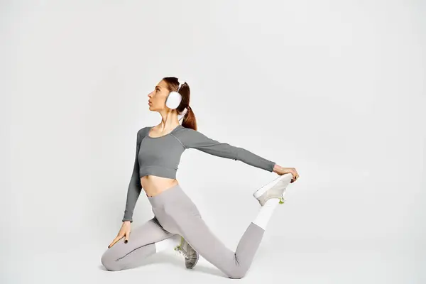 A sporty young woman in active wear working out in her headphones — Stock Photo