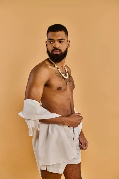 Um homem sereno com uma barba exuberante graciosamente adorna uma toalha branca nítida, exalando uma sensação de calma e relaxamento. — Fotografia de Stock