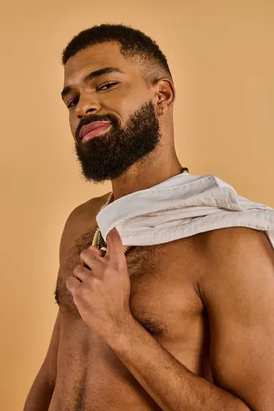 Um homem barbudo fica de pé com uma toalha enrolada em torno de seu pescoço, provavelmente em uma barbearia se preparando para um corte de cabelo ou barbear.. — Fotografia de Stock