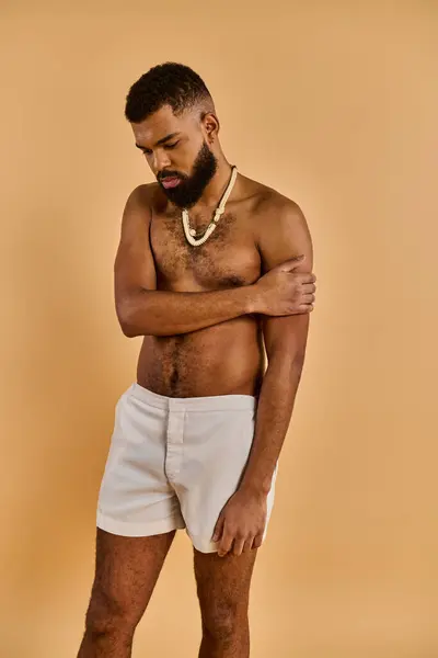 Um homem com uma barba cheia está passeando confiantemente enquanto se veste de shorts brancos, exalando uma vibração descontraída e casual.. — Fotografia de Stock