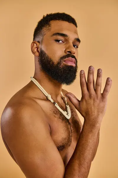 Um homem, sem camisa com uma barba áspera, está graciosamente segurando as mãos em uma pose pensativa e introspectiva. — Fotografia de Stock