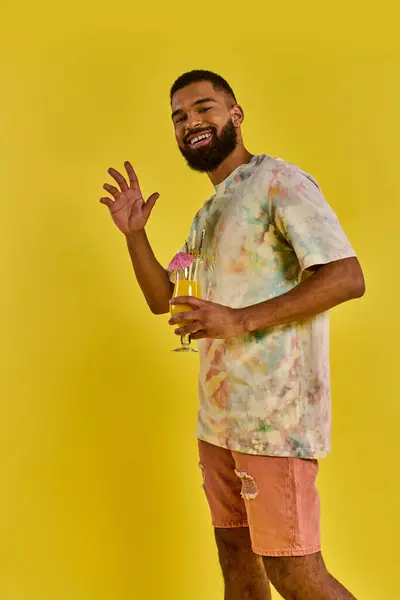 Um homem com um copo de suco de laranja na mão, desfrutando da cor vibrante e aroma refrescante da bebida cítrica. — Fotografia de Stock