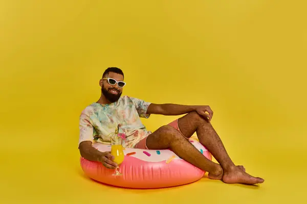 Un homme s'assied paisiblement sur un objet gonflable massif, méditant le monde autour de lui alors qu'il flotte doucement sur la surface des eaux. — Photo de stock