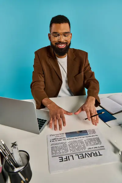 A focused man sits at a desk, typing on a laptop screen. The room is dimly lit, with the glow of the screen illuminating his face. — Stock Photo